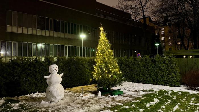 Lumiukko ja jouluvalot ilahduttivat joulukuun lauhassa illassa Helsingissä.