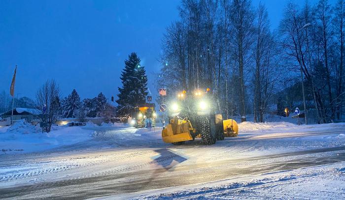 Aura-autoja työssään lumisateessa.