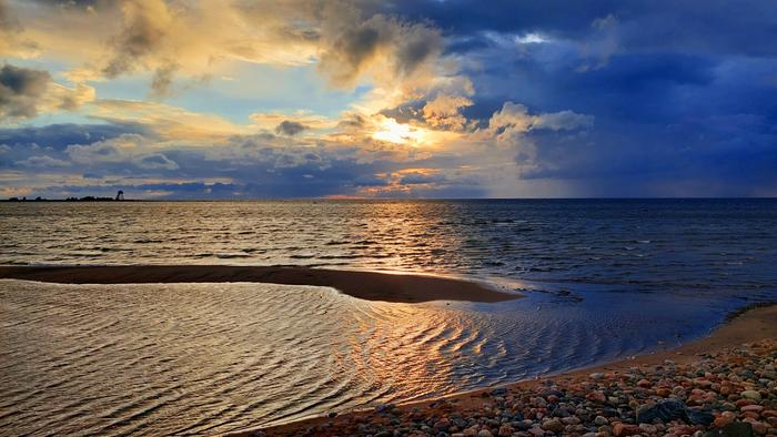 Vaihtelevan sään taivas: aurinkoa, sadetta, pilviä, tuulta.