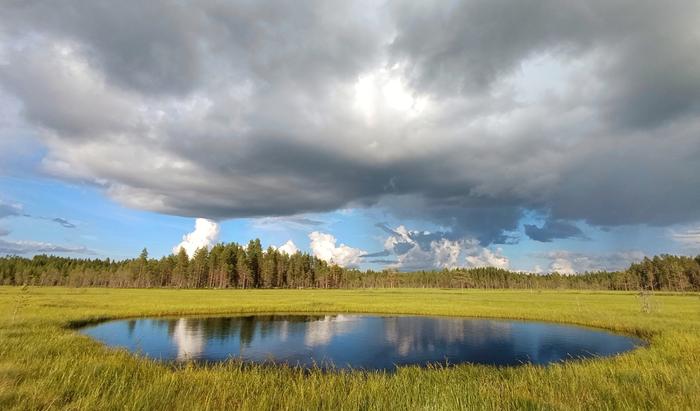 Kuuropilviä lammen yllä.